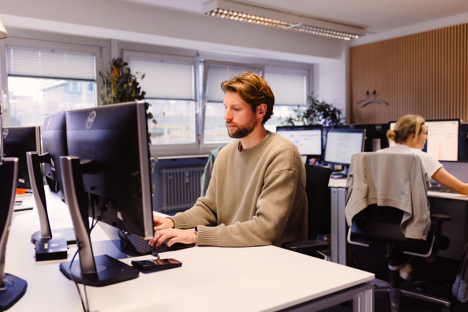 A render of three white cylindrical columns, against a warm creme background
